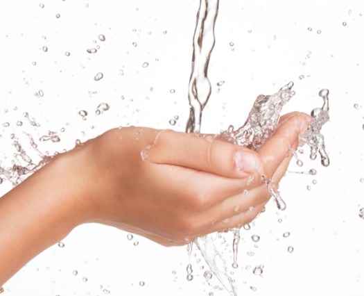 Hands under flowing water representing specialty water-treatment concerns